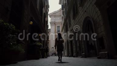 游客妇女参观风景如画的意大利罗马街道后景。 意大利度假。 罗马假日。 从后面看低角度
